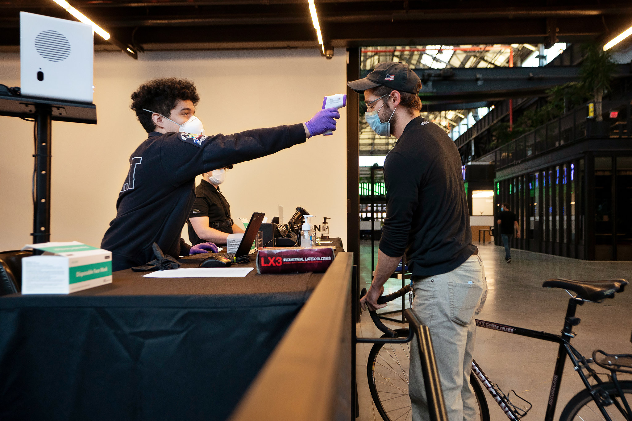 At New Lab, a technology hub in Brooklyn, workers will undergo temperature checks and have the choice of wearing a device that buzzes whenever colleagues get too close to each other.