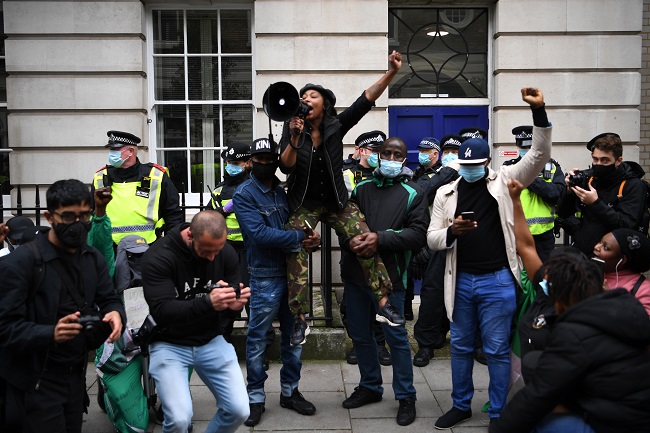 Protestors shout slogans as they raise their fists during a protest action against police brutality in Nigeria, in New Cavendish Street in central London on October 24, 2020.