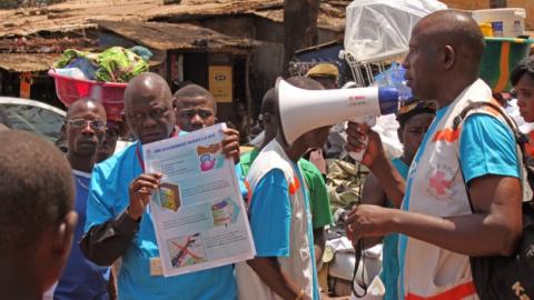Health workers teach people about the Ebola virus