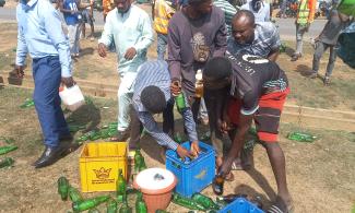 Abuja Residents Storm Accident Scene With Buckets, Others For Free Beer As Loaded Truck Falls Over