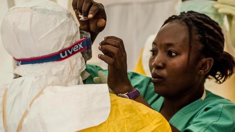 A nurse helps a health worker put on protective gear before treating Ebola patients at a clinic in Kailahun, Sierra Leone, in July.